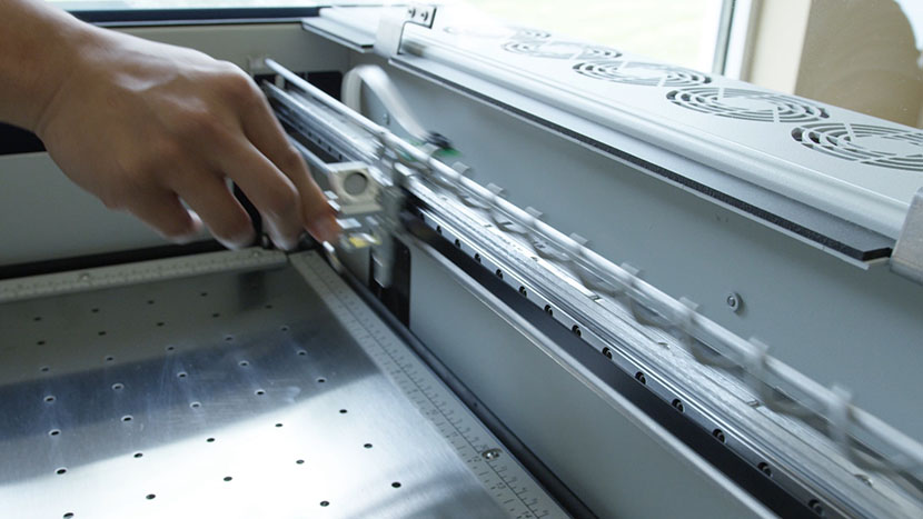 Move the lens assembly back and forth along the bearing rail to spread the grease evenly. Moving the lens assembly back and forth along the bearing rail.