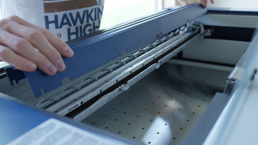 Slide the X-Axis Assembly cover over the loosened screws. Putting the cover back on the X-Axis Assembly.