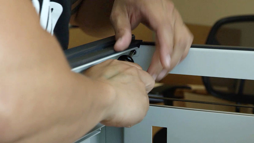 Remove the two screws at the top corners Removing one of the top corner screws