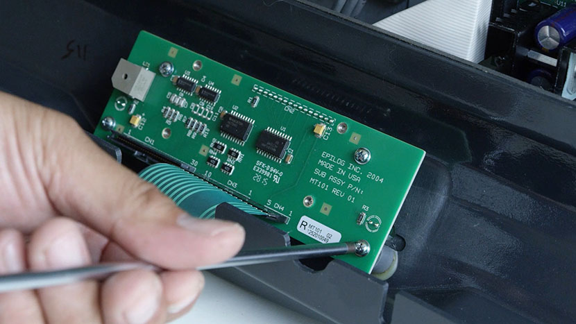 Remove the four PCB screws Removing the screws securing the PCB to the bezel