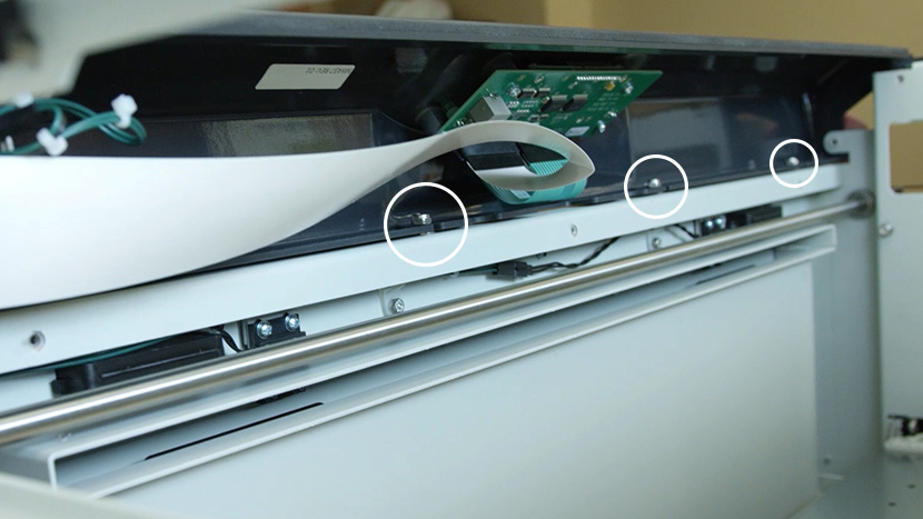 Slide the bezel under the four nuts Sliding the bezel back onto the machine