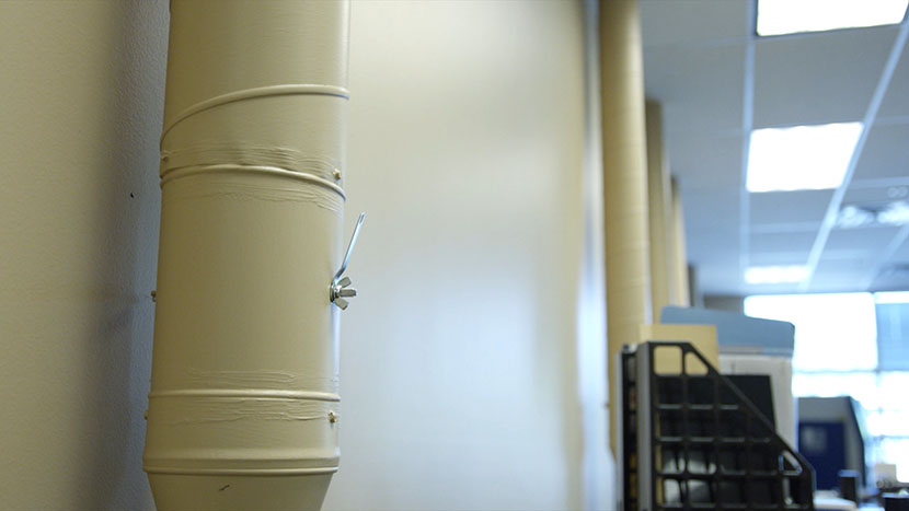 Wall-mounted piping serves as the intake for the building"s ventilation system. Metal piping that serves as intake for the building's ventilation system.