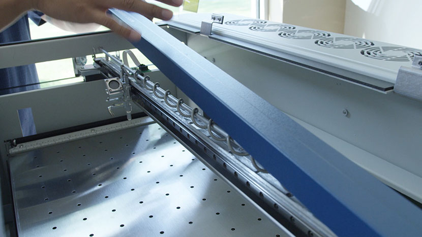 Remove the X-Axis Assembly cover. Lifting the cover off of the X-Axis Assembly.