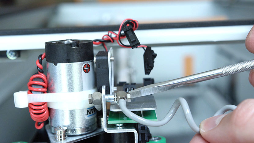 Disconnect the X-Axis flex cable. Grasping the X-Axis flex cable.