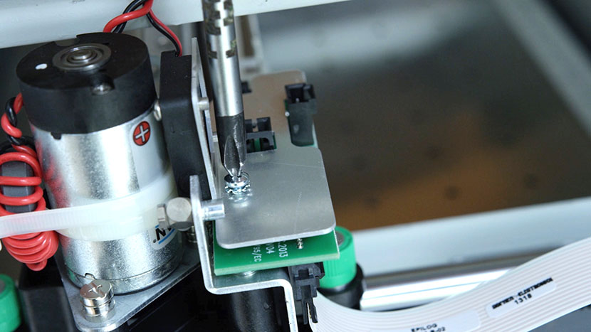 Remove the two screws securing the fan assembly. Unscrewing the two screws that secure the fan assembly.