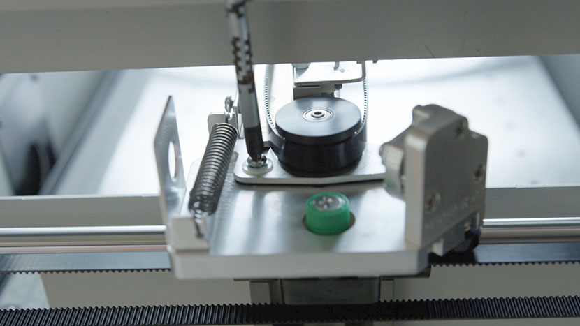 Loosen the screw holding the sliding plate in place. Loosening the screw that holds the pulley sliding plate in place.