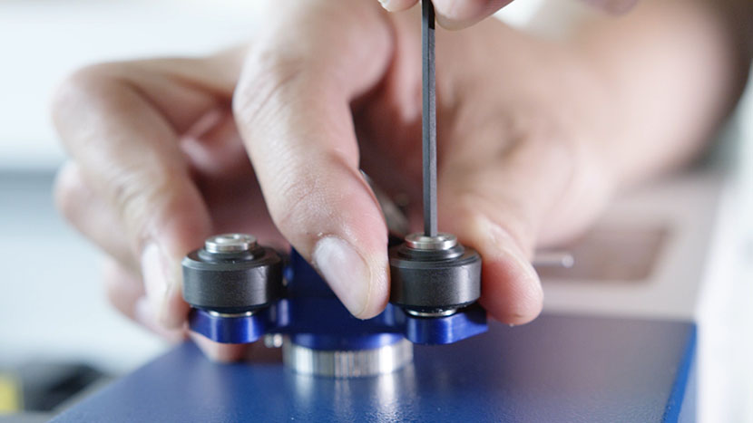 Remove the three rollers using a 3/32" hex key. Unscrewing the three carriage rollers with a 3/32" hex key.