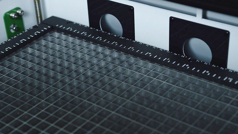 The three round exhaust ports below the slots pull air through the bottom of the cutting table. The vector grid and the back exhaust ports.