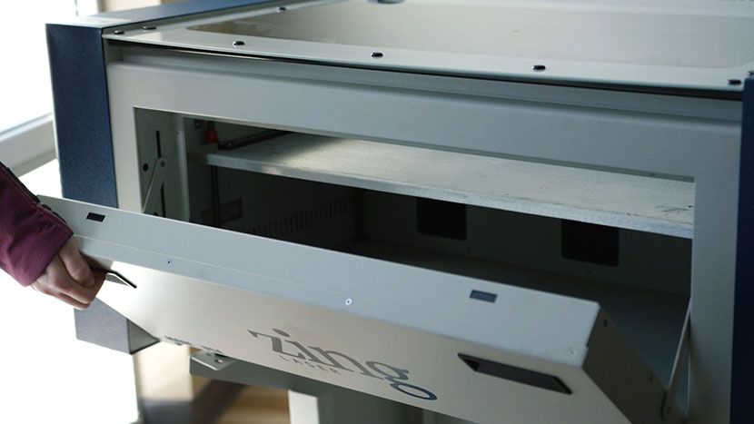 The front safety-interlocked door provides further access to the engraving area. Opening the Zing's front door.