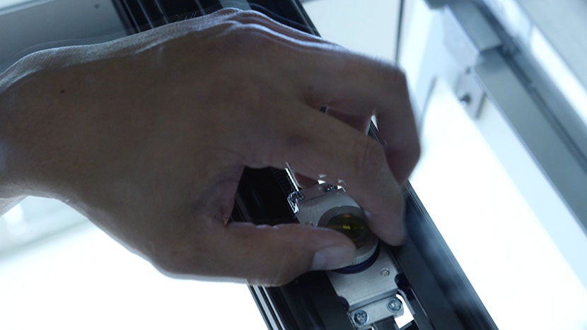 Screw the lens back into place underneath the carriage. Screwing the lens back into the lens assembly.