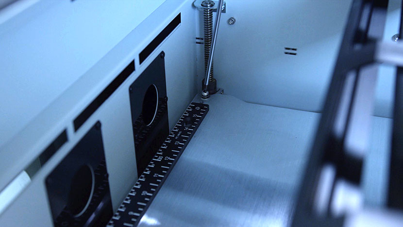 Remove the four screws located at the corners of the engraving table. Removing the back right table screw.