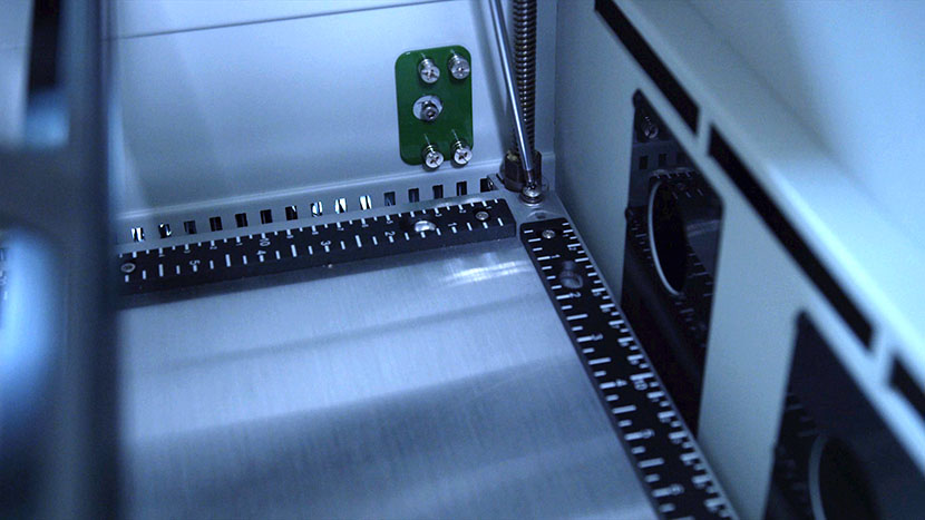 Remove the four screws located at the corners of the engraving table. Removing the back left table screw.