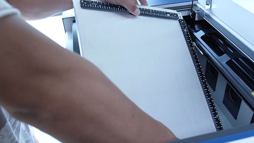 Tilt the table and lift it out. Removing the engraving table from the machine.