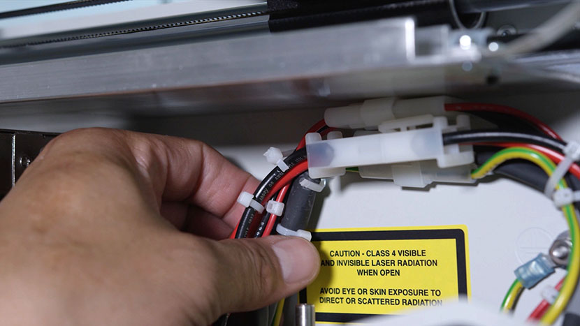 Cut the zip tie securing the wires to the chassis. Power supply cords in a cut zip tie.