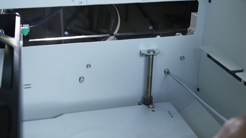 Reattach the two captive screws to the power supply on the inside of the machine. Tightening the power supply captive screws.