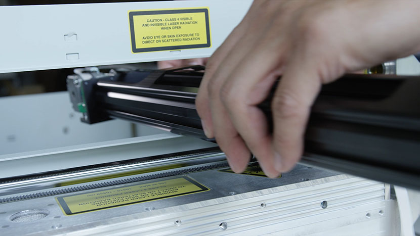 Slide the new x-axis assembly in the left side of the machine. The x-axis part-way in the machine.