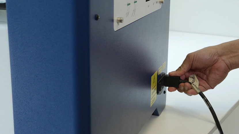 Plug the machine in and turn it on. Putting the power cord into the machine.