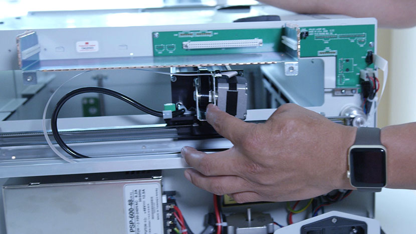 Push the x-axis assembly to the back of the machine. The x-axis assembly being pushed to the back of the machine.