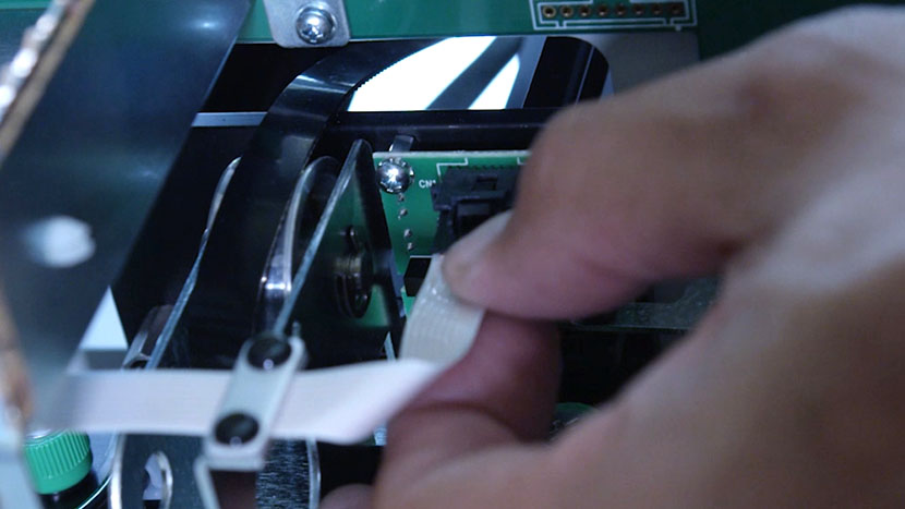 Unclip the flex cable. Preparing to unplug the motor's flex cable.