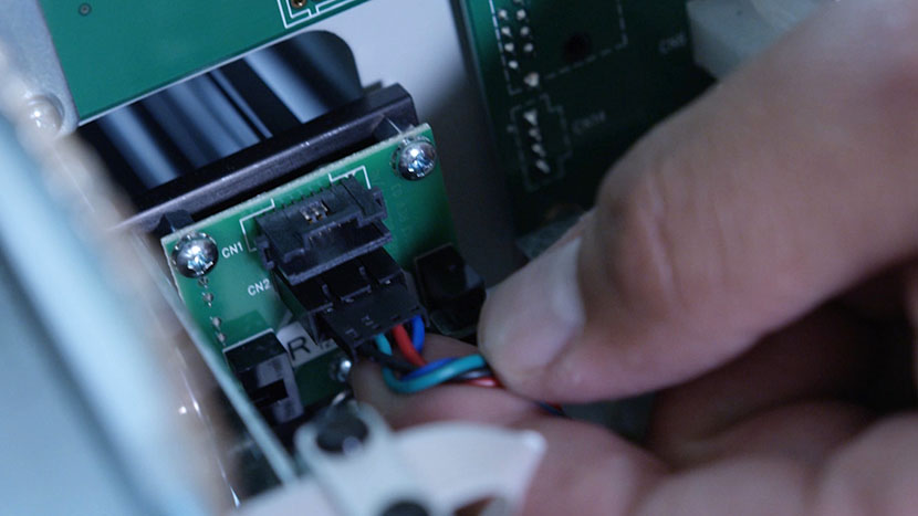 Disconnect the electrical connection behind the motor and set the old motor aside. Preparing to unplug the motor's electrical connection.