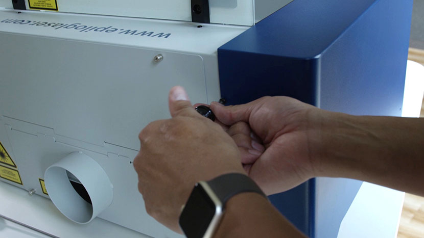 Tighten the screw on the back of the machine. Screwing in the left side panel's back screw.