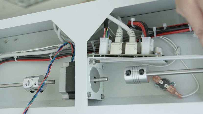 Make sure the fan control board panel rests on top of the two upper mounting screws. Inserting one of the top two Y-Motor mounting screws.
