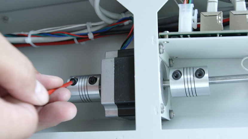 Tighten the hex screws on the left drive coupler. Tightening the hex screws on the left drive coupler.